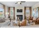 Cozy living room featuring a fireplace, large windows, ceiling fan, and comfortable seating at 26 Kensington St, Kingston, GA 30145
