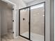 Modern walk-in shower with glass door, tiled walls and a neutral color palette at 26 Kensington St, Kingston, GA 30145
