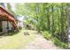Landscaped backyard featuring a wooden deck, fire pit, and mature trees at 2945 Barimore Pl, Dacula, GA 30019