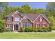 Charming two-story brick home featuring red shutters and well-manicured front lawn at 2945 Barimore Pl, Dacula, GA 30019
