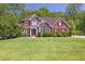 Beautifully landscaped brick home with lush green lawn and mature trees at 2945 Barimore Pl, Dacula, GA 30019