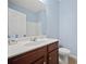 Well-lit bathroom featuring a vanity with dark wood cabinets, ample counter space, and a toilet at 3203 Cyrus Point Nw Ln, Kennesaw, GA 30152