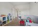 Cozy, carpeted bedroom featuring a mini crib, storage shelving, and natural light at 3203 Cyrus Point Nw Ln, Kennesaw, GA 30152