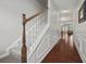 Hallway features hardwood floors, staircase with stained wood handrail, and paneled walls at 3203 Cyrus Point Nw Ln, Kennesaw, GA 30152
