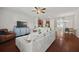 Open-concept living room featuring hardwood floors, ceiling fan and connection to the kitchen and dining areas at 3203 Cyrus Point Nw Ln, Kennesaw, GA 30152