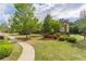 Well-maintained community with manicured lawns, lush landscaping, and charming brick buildings under a cloudy sky at 4236 Tacoma Trce, Suwanee, GA 30024