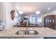 Kitchen island featuring a granite countertop, stainless steel sink, and seating area at 4236 Tacoma Trce, Suwanee, GA 30024
