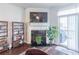 Living room featuring a fireplace, TV, sliding glass doors, and hardwood floors at 4236 Tacoma Trce, Suwanee, GA 30024