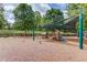 Community playground with play structures, swings, and slides in a wooded area at 4236 Tacoma Trce, Suwanee, GA 30024