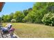 Expansive backyard with lush greenery, mature trees, and a pergola-covered patio at 6565 Bentley Ridge Dr, Cumming, GA 30040