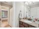 Bathroom featuring granite vanity, mirror, and a view of the hallway at 6565 Bentley Ridge Dr, Cumming, GA 30040
