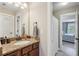 Bathroom featuring granite vanity, mirror, and a view of the hallway at 6565 Bentley Ridge Dr, Cumming, GA 30040