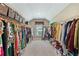 Spacious walk-in closet with custom shelving, ample storage and natural light from the window at 6565 Bentley Ridge Dr, Cumming, GA 30040