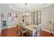 Elegant dining room with tray ceiling, hardwood floors, chandelier, and stylish decor at 6565 Bentley Ridge Dr, Cumming, GA 30040