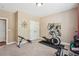 Well-lit carpeted exercise room with elliptical, weights, and closet at 6565 Bentley Ridge Dr, Cumming, GA 30040