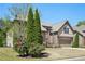 Attractive home showcasing lush landscaping with mature trees and blooming bushes at 6565 Bentley Ridge Dr, Cumming, GA 30040