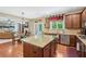 Open concept kitchen, hardwood floors, stainless steel appliances, island, and a view to living area at 6565 Bentley Ridge Dr, Cumming, GA 30040