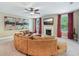 Spacious living room featuring a cozy fireplace, fan, and plush, curved sofa at 6565 Bentley Ridge Dr, Cumming, GA 30040