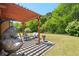 Inviting backyard patio featuring comfortable seating, a pergola, and a view of the landscaped lawn at 6565 Bentley Ridge Dr, Cumming, GA 30040