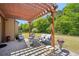 Beautiful backyard patio with a pergola, ample seating, and a view of the green lawn and trees at 6565 Bentley Ridge Dr, Cumming, GA 30040