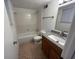 Well-lit bathroom with granite countertop, wood cabinets, and shower-tub combo at 981 Dundee Dr, Lilburn, GA 30047