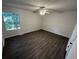 Bright bedroom features a ceiling fan, natural light, and sleek dark wood flooring at 981 Dundee Dr, Lilburn, GA 30047