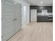 Basement level with wood flooring, dark cabinets and double-door access at 1304 Six Sisters St, Dacula, GA 30019