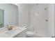 Bright bathroom with a white vanity, toilet and tiled shower at 1304 Six Sisters St, Dacula, GA 30019