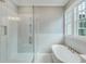 Bright bathroom featuring tile floors, a shower, and a soaking tub at 1304 Six Sisters St, Dacula, GA 30019