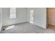 Spacious bedroom with neutral carpet, white walls, and a view of the doorway to the bathroom at 1304 Six Sisters St, Dacula, GA 30019