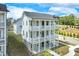 Stunning three-story home showcasing white siding, stacked porches, and meticulous landscaping at 1304 Six Sisters St, Dacula, GA 30019