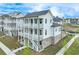 Charming three-story townhouse with a white exterior, multiple balconies, and landscaped front yard at 1304 Six Sisters St, Dacula, GA 30019