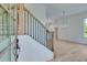 Bright foyer with hardwood floors, iron railing and modern chandelier at 1304 Six Sisters St, Dacula, GA 30019