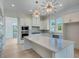 Bright, modern kitchen with a large island, stylish lighting, and stainless steel appliances at 1304 Six Sisters St, Dacula, GA 30019