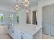 Kitchen island with a light countertop, cabinets, and view of adjacent breakfast area at 1304 Six Sisters St, Dacula, GA 30019