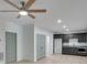 Living room with modern ceiling fan, wood flooring, and cabinets at 1304 Six Sisters St, Dacula, GA 30019