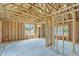 Spacious living room with wood framing, large windows, and concrete flooring during home construction at 1304 Six Sisters St, Dacula, GA 30019