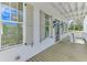Inviting covered porch with neutral shutters and glass paned front door at 1304 Six Sisters St, Dacula, GA 30019