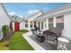 Private backyard with patio, outdoor furniture, manicured artificial turf, and a red garden gate at 142 Jaime Dr, Canton, GA 30114