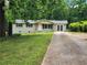 Charming single-story home featuring a well-maintained lawn and a long driveway leading to a two-door garage at 4030 Hiram Ct, Powder Springs, GA 30127