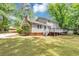 Rear view of home featuring a spacious yard and wooden deck at 4261 Autumn Hill Dr, Stone Mountain, GA 30083