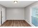 This bedroom has hardwood floors, a window, closet, and a modern light fixture at 4261 Autumn Hill Dr, Stone Mountain, GA 30083