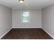 Empty bedroom with window, light grey walls, and dark hardwood flooring at 4261 Autumn Hill Dr, Stone Mountain, GA 30083