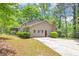 Side view of a house with a chimney and a concrete driveway and some manicured shrubbery at 4261 Autumn Hill Dr, Stone Mountain, GA 30083