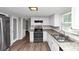 Kitchen featuring stainless steel appliances, white cabinets, and a view into the living space at 4261 Autumn Hill Dr, Stone Mountain, GA 30083