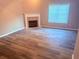 Inviting living room featuring a fireplace, new hardwood floors and a large, light-filled window at 11447 Vinea Ln, Hampton, GA 30228