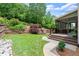 Landscaped backyard with a stone wall, wooden fence and path to deck at 1286 Whisper Cove Dr, Buford, GA 30518