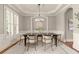 Formal dining room featuring elegant trim, a stylish chandelier, and ample natural light at 1286 Whisper Cove Dr, Buford, GA 30518