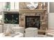 Close-up of a cozy stone fireplace with mantle and a modern television set above built-in shelving at 1286 Whisper Cove Dr, Buford, GA 30518