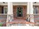 Elegant front entryway with stone columns, brickwork, and a black door with glass detailing at 1286 Whisper Cove Dr, Buford, GA 30518